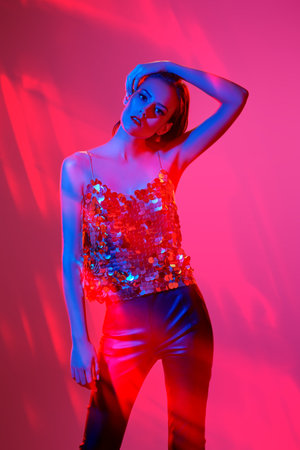 Party and disco style. Portrait of an attractive girl with bright shiny make-up posing in a golden...