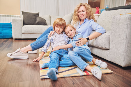 Happy family life at home. A mother spends time with her adorable children playing in a living room.の写真素材