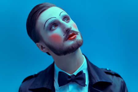 Art and fashion. Portrait of a young man with makeup in the style of the 20s in an elegant suit playing different life roles. Male mime artist.の写真素材