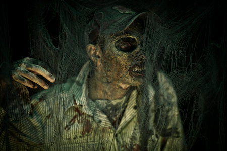 Zombie climbs out of the grave in the night cemetery. Halloween Horror.