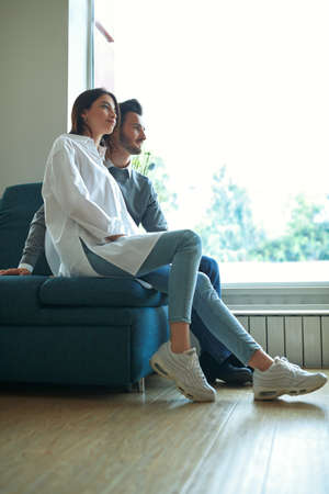 Beautiful young people in love spending time together at home. Happy couple. Home interior, furniture.の写真素材