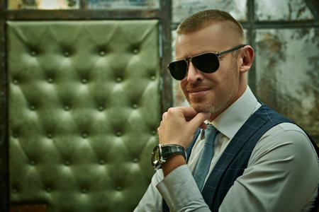 Portrait of a handsome mature man in an elegant classic suit standing in a luxury apartment. Male...