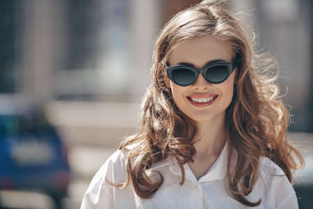 Beautiful happy girl walks around the city on a sunny summer day. Summer vacation, trips. Happy people concept.の写真素材