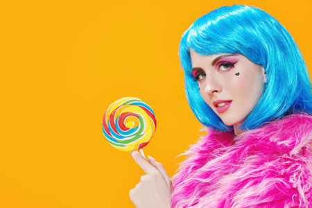Attractive party girl with bright pink makeup and blue wig wears pink fur coat and holds big...