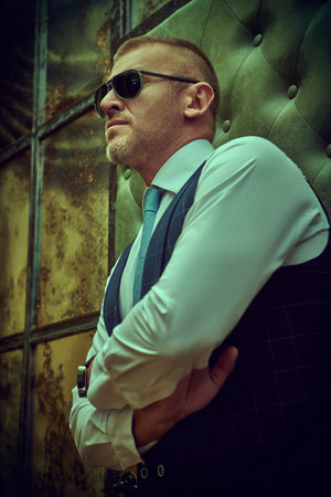 Portrait of a handsome mature man in an elegant classic suit standing in a luxury apartment. Male...
