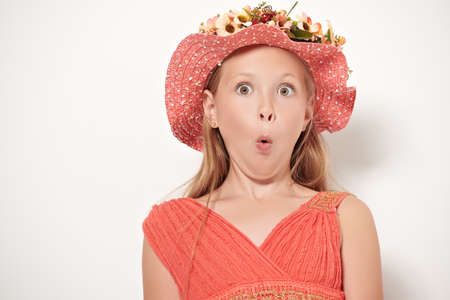 Pretty eight year old emotional girl is surprised. Studio portrait on a white background. Copy space.の写真素材