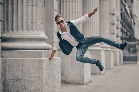 Handsome bouncing with joy guy walk on the street. Summer fashion. Summer holidays and vacation.