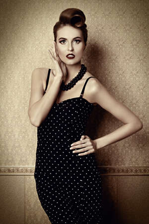 Portrait of a beautiful glamorous woman in elegant evening dress. Pin-up style in clothes, hair and make-up.の写真素材