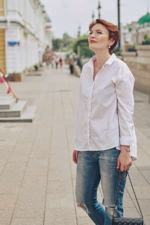 Portrait of a modern middle-aged woman in glasses on a city street on a summer day. Optics for women. Summer style.の写真素材