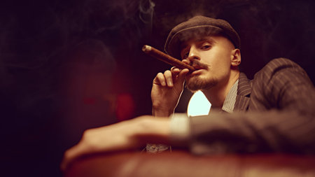 Portrait of a handsome courageous man sitting pensive in a rich setting on a leather sofa and...