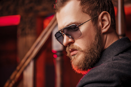A close up portrait of a stylish man wearing sunglasses. Beauty and style for men.
