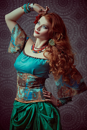 Portrait of a beautiful red-haired gypsy woman. National gypsy costume, ethnic. Make-up and hairstyle.の写真素材