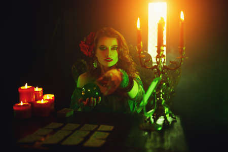 Magnificent fortune teller woman reading future on magical crystal ball and tarot cards.の写真素材