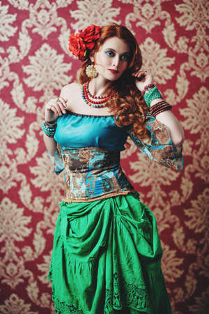 Portrait of a beautiful red-haired gypsy woman. National gypsy costume, ethnic. Make-up and hairstyle.の写真素材