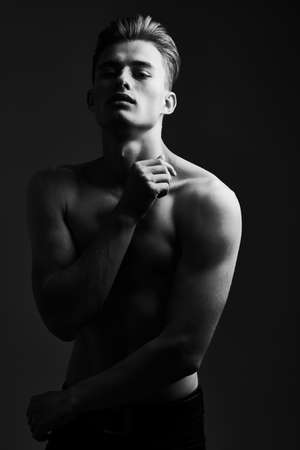 Black-and-white portrait of a handsome athletic young man with perfect muscular body. Men's beauty and health. Sports and bodybuilding.の写真素材
