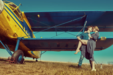 Full length portrait of a beautiful passionate couple in love is going to travel by plane. Adventure...