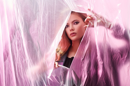 Art beauty fashion portrait of a gorgeous young woman posing with polyethylene. Beauty, make-up and...