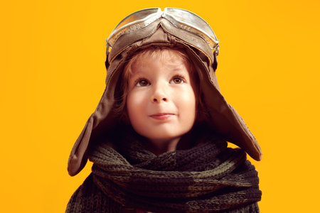 Portrait of a cute little boy dreaming of becoming a pilot. Childhood. Fantasy, imagination. Studio...