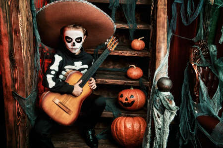 Sugar skull child boy in an old wooden house. Dia de los muertos. Day of The Dead. Halloween.の写真素材