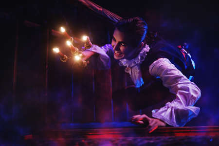 A bloodthirsty vampire aristocrat sneaks around the castle in the night in search of a victim. 19th century style. Halloween.の写真素材
