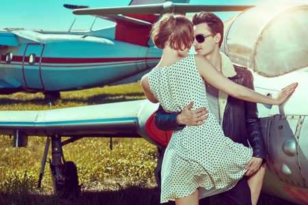 Portrait of a beautiful passionate couple in love is going to travel by plane. Adventure and travel concept.の写真素材