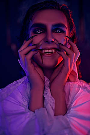 Portrait of a handsome bloodthirsty vampire with a grin on his face. Halloween.の写真素材