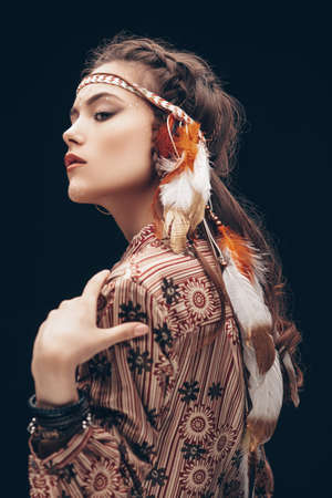 Portrait of a beautiful young woman with hairstyle and make-up in boho style.の写真素材