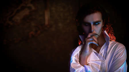 Handsome bloodthirsty vampire standing in his castle. Halloween.の写真素材