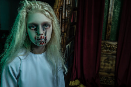 A portrait of a scary pale girl from a horror film in a room. Zombie, halloween.の写真素材