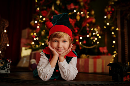Christmas and New Year concept. Cute little boy in Santa Claus hat smiling at camera. Christmas by a...