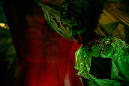 Halloween concept. Portrait of a scary zombie boy teenager in an abandoned house.の写真素材