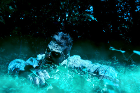 Zombie climbs out of the grave in the night cemetery. Halloween Horror.