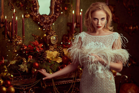 Christmas and New Year magic. Charming happy young woman in a festive evening dress and with...