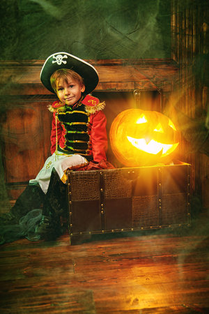 Little boy in a costume of pirate at a Halloween party. Halloween decorations of an old castle.の写真素材