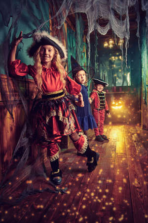 Happy children in carnival costumes celebrate halloween in the old castle. Halloween.の写真素材
