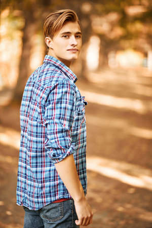 Portrait of a handsome young man on an sunny autumn forest. Male beauty.の写真素材