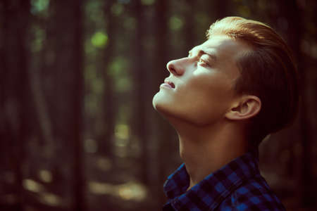 Portrait of a handsome young man in the forest. Male beauty.の写真素材