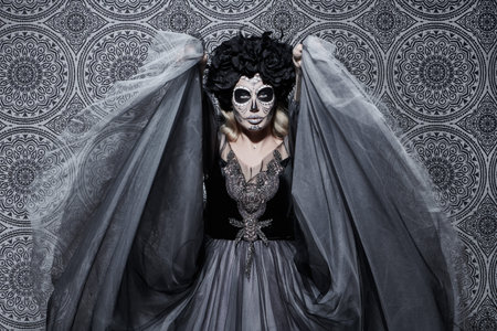 Beautiful Calavera Catrina over vintage background. Fashion model with sugar skull makeup. Dia de...