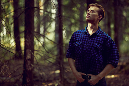 Handsome masculine man in the wild forest. Adventure, spirit of freedom. Active lifestyle.
