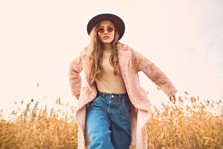 Autumn fashion. Emotional young woman in trendy autumn clothes poses in motion against the backdrop...
