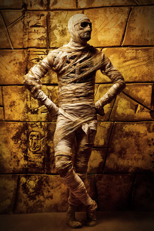 Halloween mummy is posing against the background of ruined wall. Halloween. Ancient Egyptian...