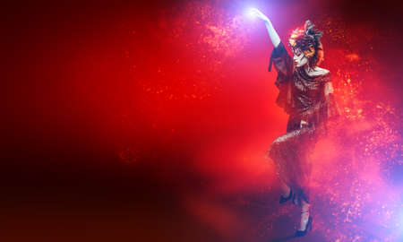 Portrait of a beautiful and scary Calavera Catrina surrounded by a mysterious fog on black and glittering red background. Sugar skull makeup and costume. Dia de los muertos. Day of The Dead. Halloween.の写真素材
