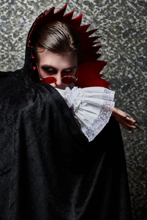 Portrait of a traditional vampire aristocrat of the 19th century covering his face with a Cape....