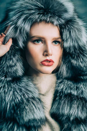 Portrait of a gorgeous fashionable woman in a silver fox fur coat with hood. Winter fur coat fashion.の写真素材