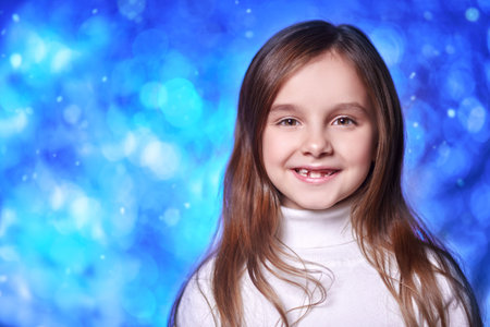 Christmas and New Year celebration. Portrait of a cute little girl on the background of sparkling...