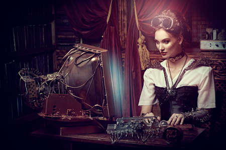 Beautiful steampunk lady scientist inventor works in her laboratory with Victorian interior.の写真素材