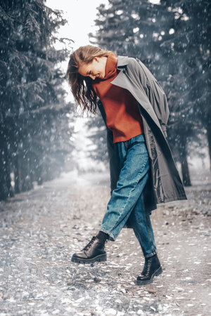 Happy winter day. Full length portrait of a beautiful young woman in a winter park under the snow.