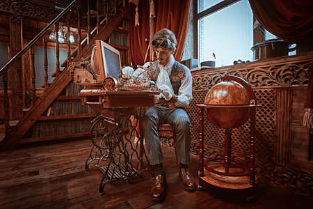Handsome steampunk man scientist inventor works in his laboratory with Victorian interior.の写真素材