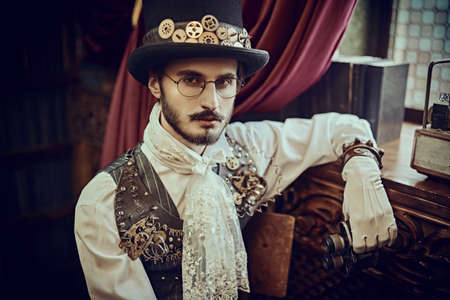 Portrait of a scientist steampunk man inventor at his home with Victorian interior. Adventure world of steampunk.の写真素材