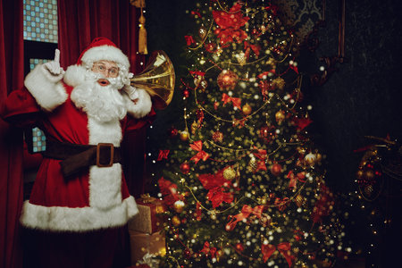 Jolly Santa Claus sneaked into the house and listens. Christmas and New Year concept.の写真素材
